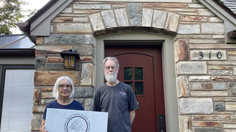 man and woman standing on front stoop with sign that says award winner 2023