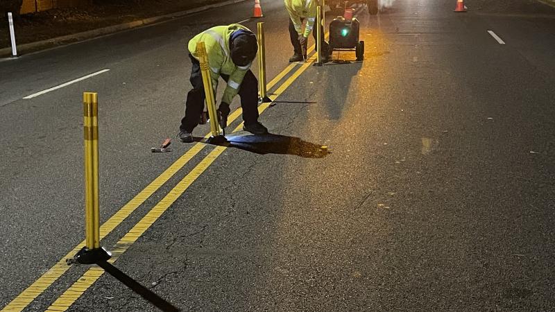 Two Traffic operations employees installing posts and markings