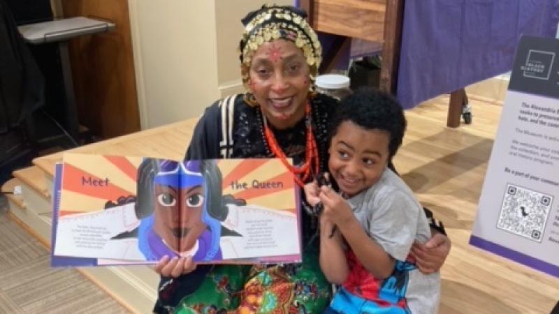 Woman holding a picture book, with child