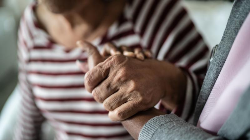caregiver holding senior's hand