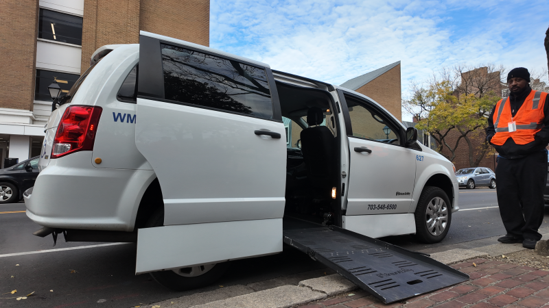 A paratransit van with the door open and the ramp down.