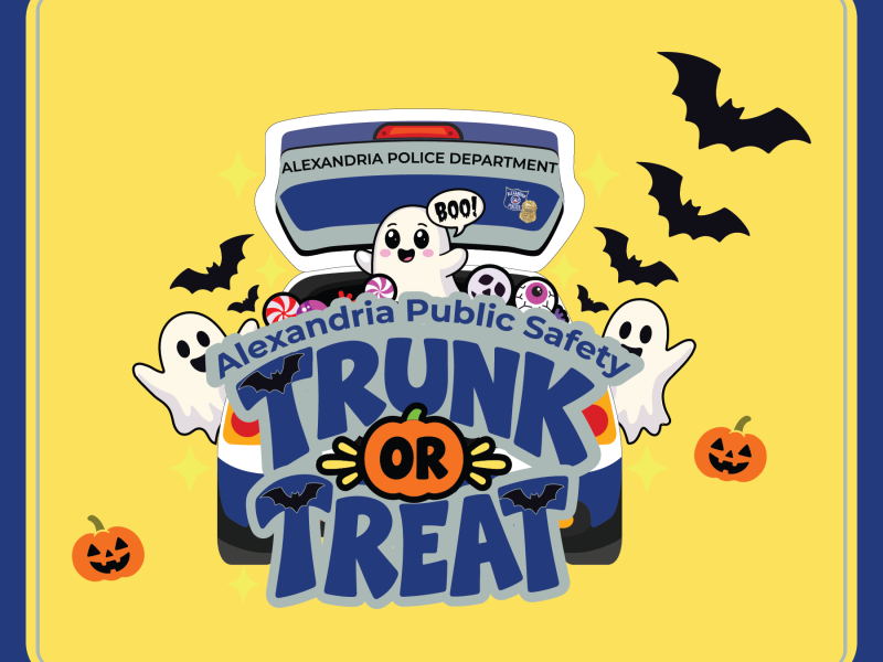 Alexandria Public Safety Trunk or Treat graphic featuring a cartoon Alexandria Police vehicle with its trunk open, filled with Halloween candy and a smiling ghost saying “Boo!” Large blue lettering reads “Alexandria Public Safety Trunk or Treat,” with an orange pumpkin forming the word “OR.” Additional smiling ghosts, black bats, jack-o’-lanterns and yellow sparkles decorate the bright yellow background framed by a dark blue border.