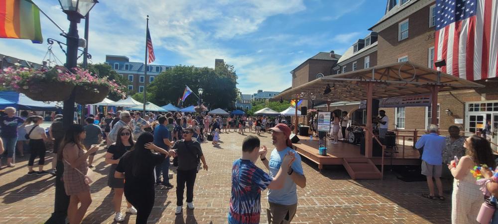 People dancing in front of stage at pride fair