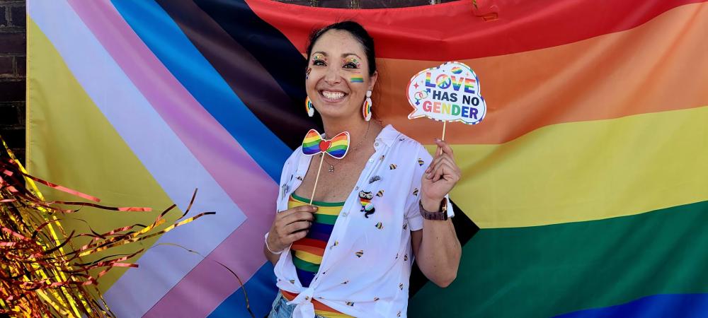 Person posing in front of pride flag