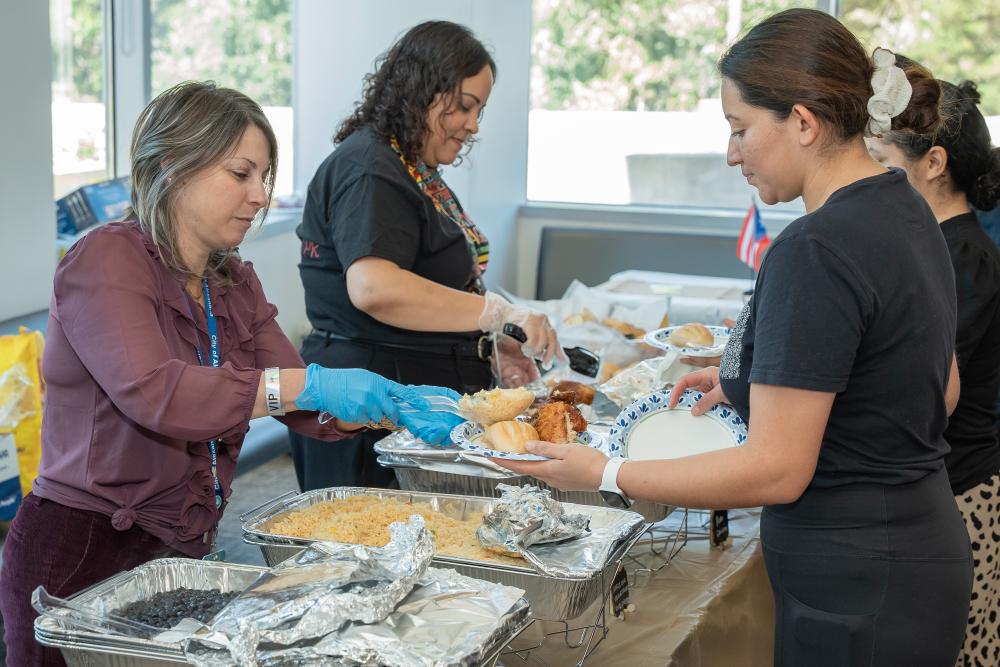 two women serve food to employees