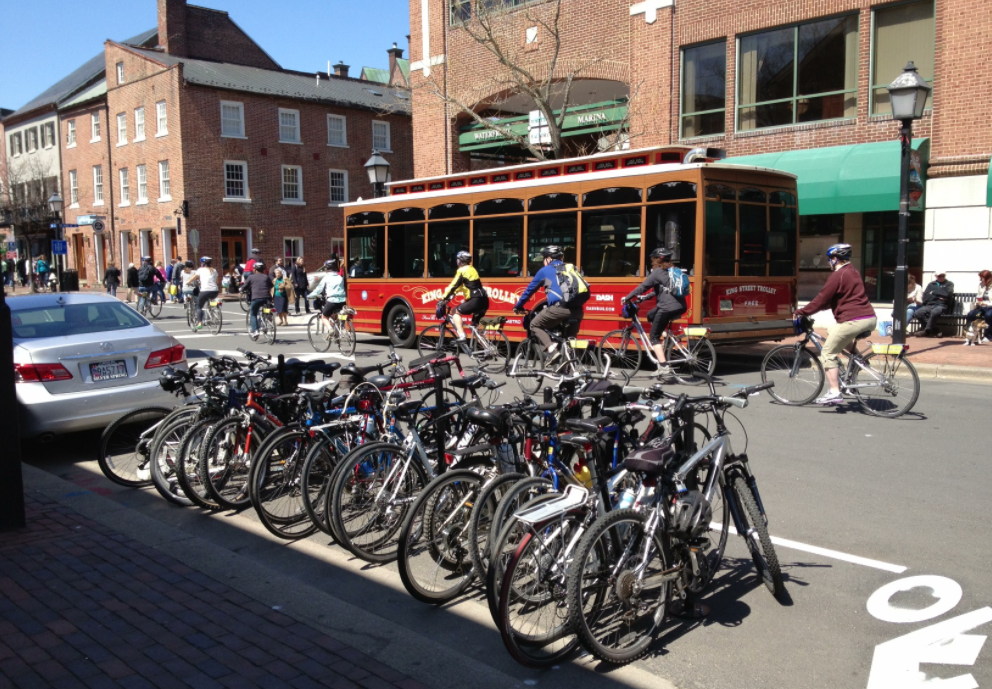 A photo of a bicycle corral filled with parked bikes on lower King Street in Alexandria