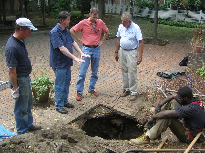 Archaeologist inspects sink hole.