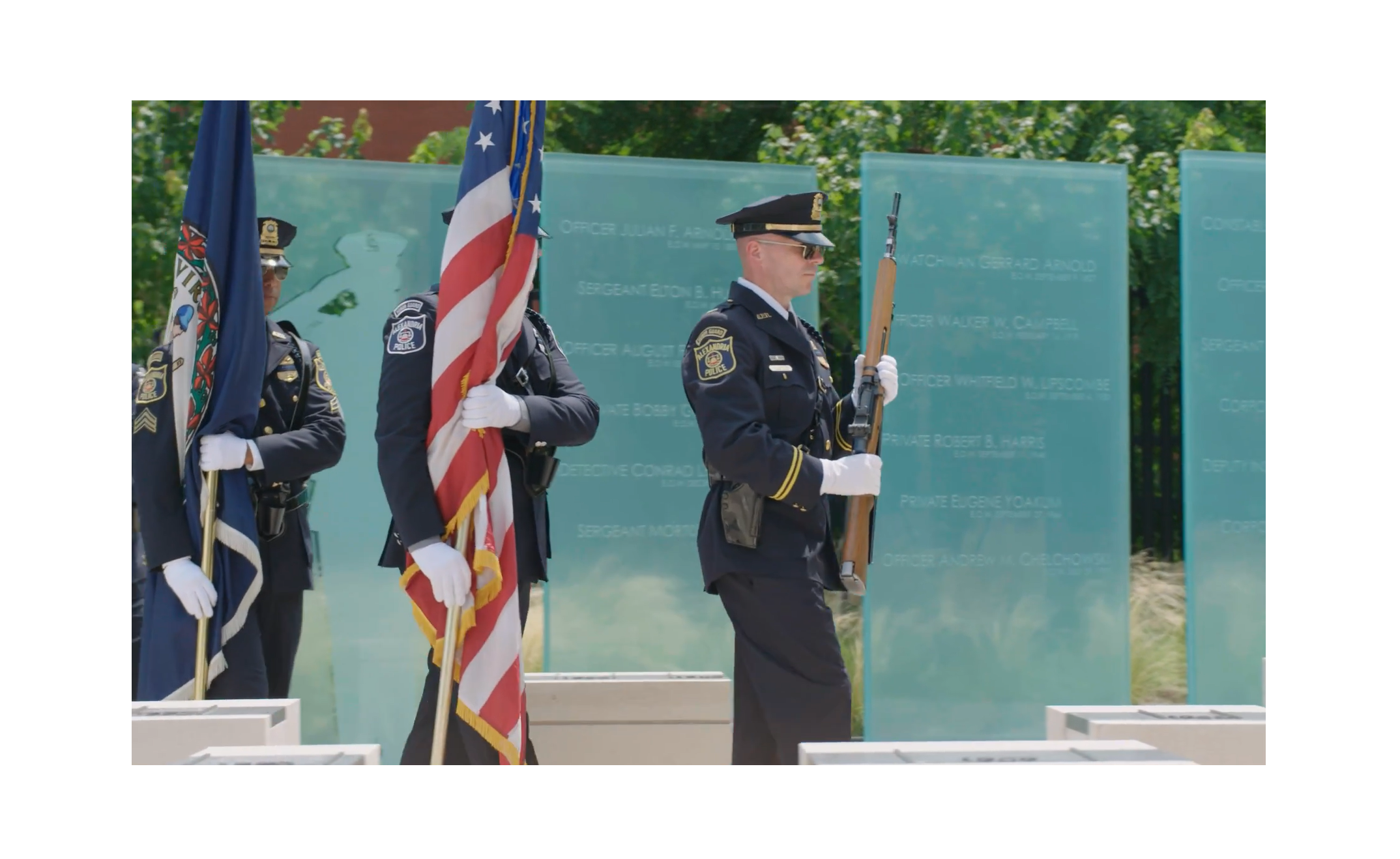Members of the honor guard parade past the American flag