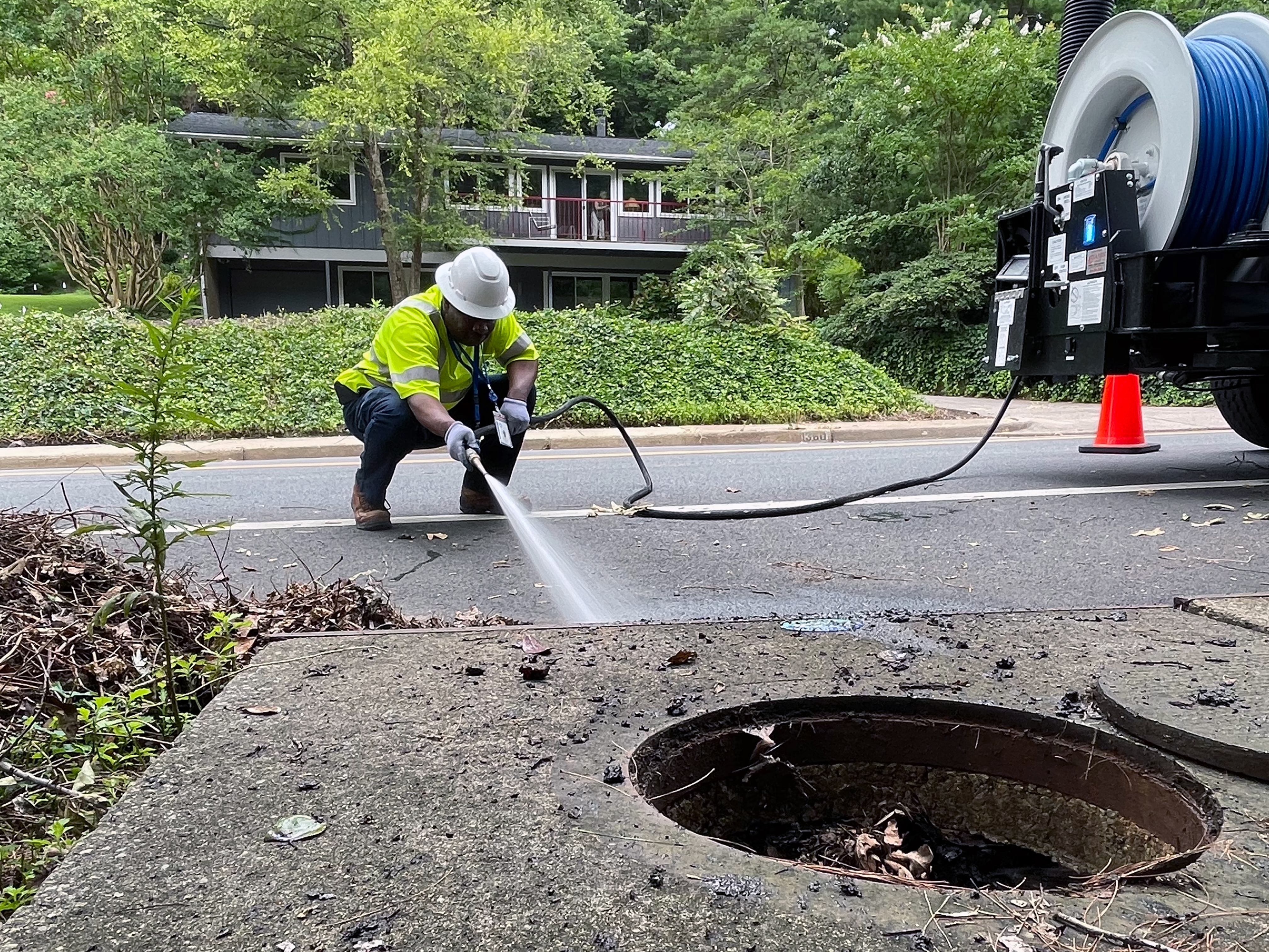 Photo of a TES employee clearing a manhole and storm drain