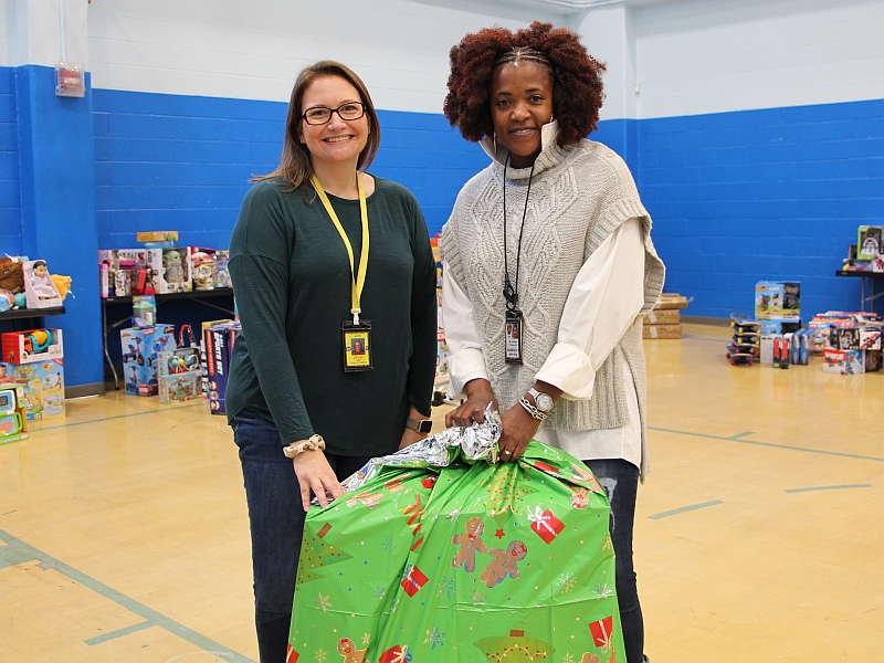 two professional Sheriff's Office employees with large giftwrapped package