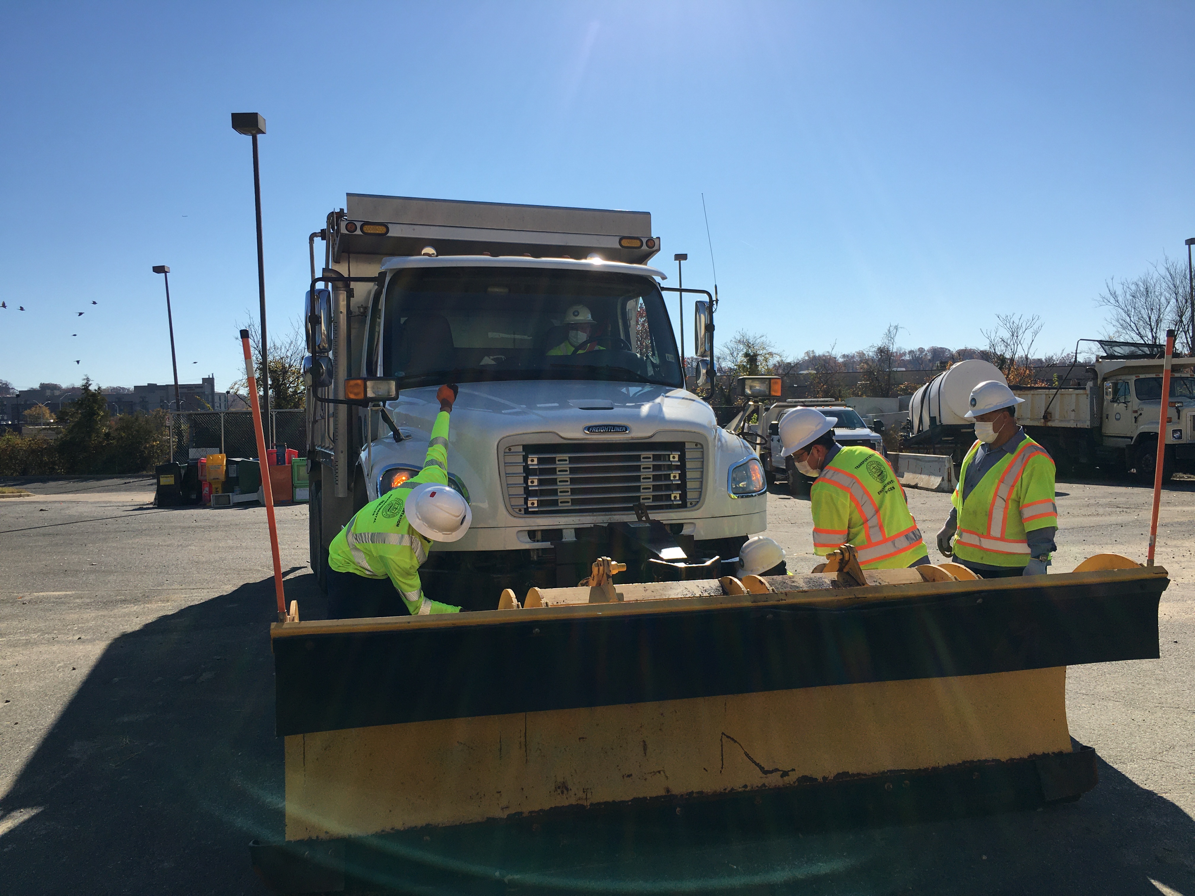 Photo of TES employees preparing a snow plow for service.