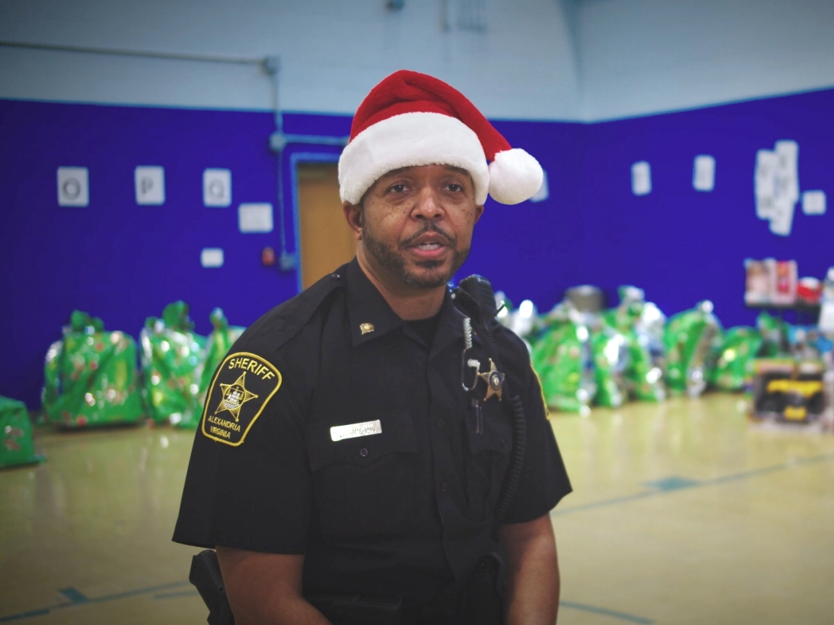 deputy in uniform wearing a red and white Santa hat