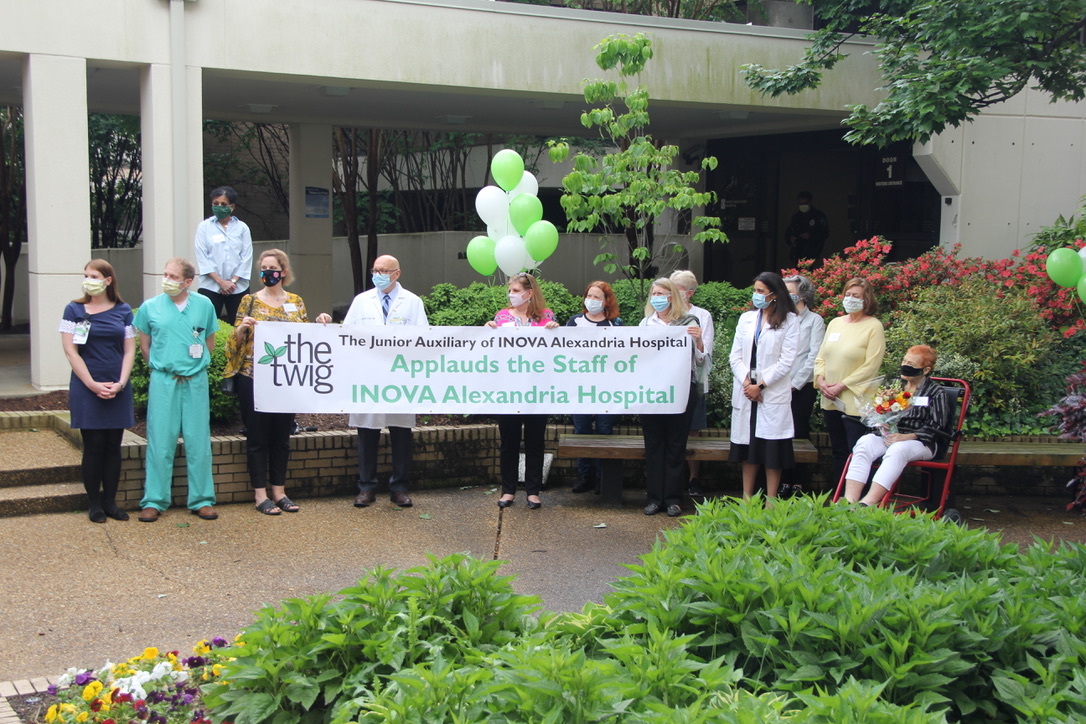 People outside of hospital with banner and balloons