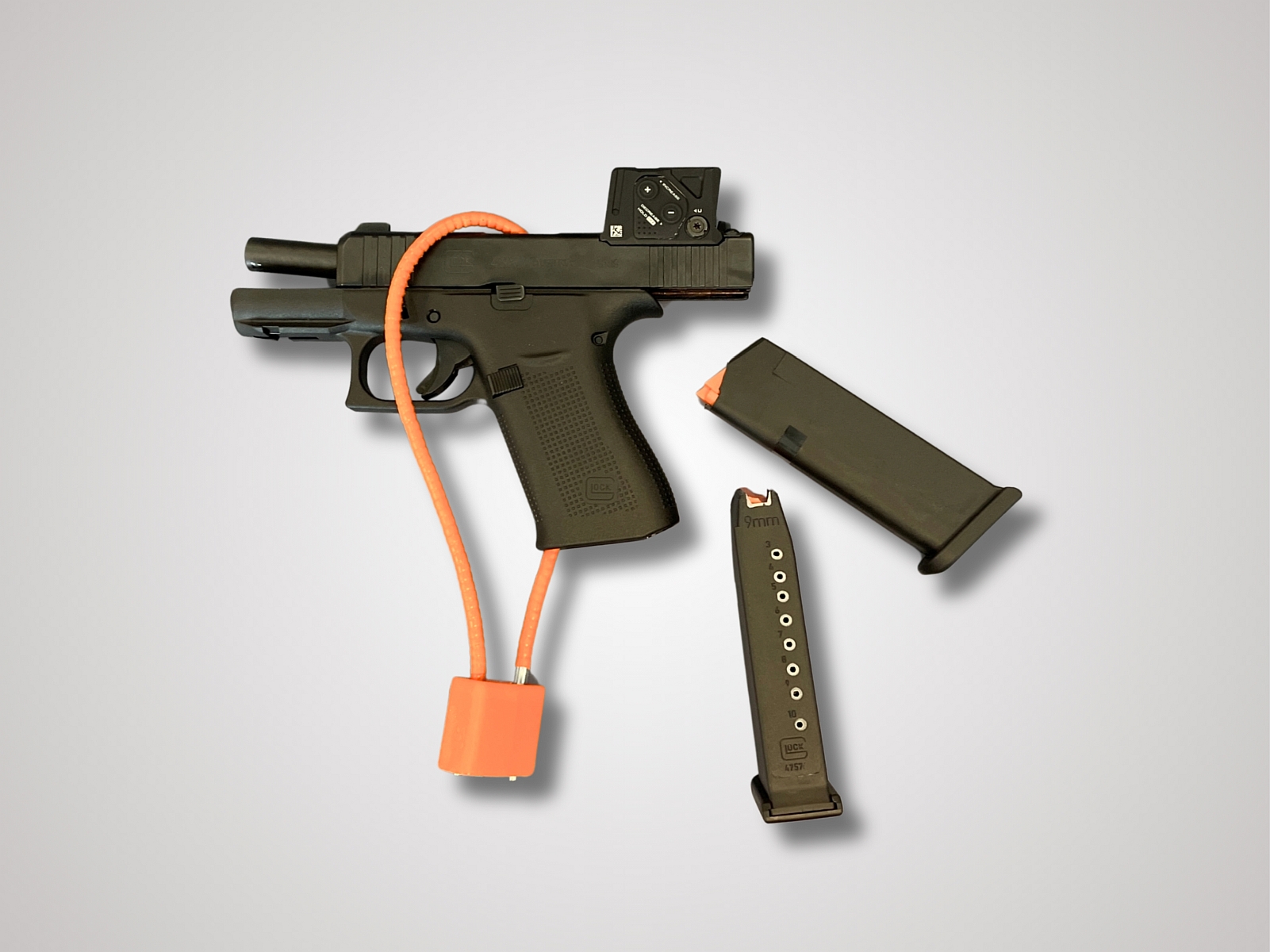 black handgun secured with orange cable lock and two magazines