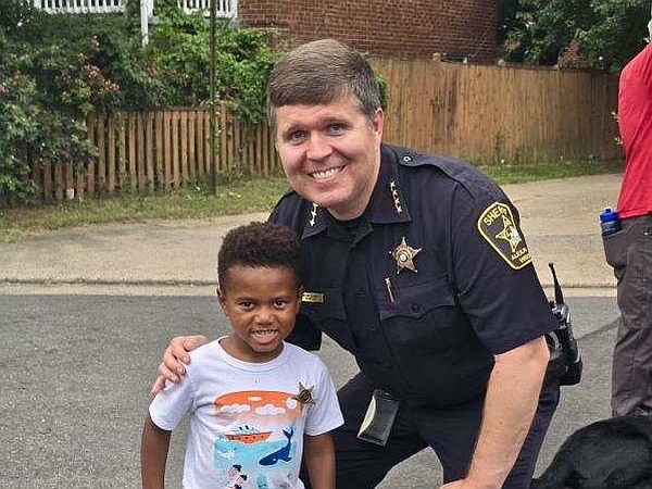 Sheriff Casey in blue uniform with young boy wearing junior deputy badge