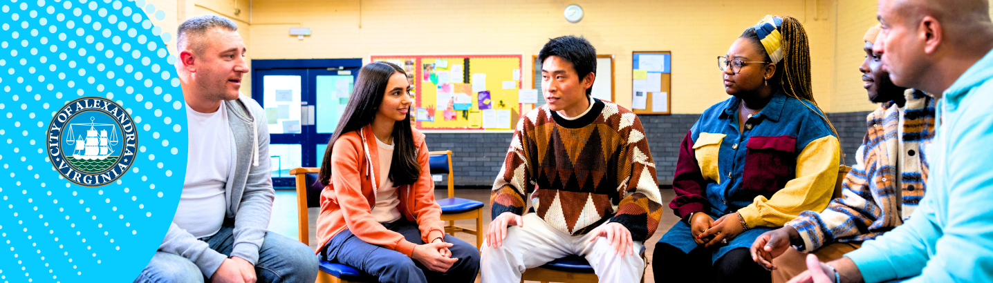 Diverse group of adults sitting in a half circle indoors engaged in conversation