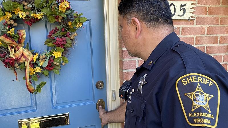 deputy checking door of home
