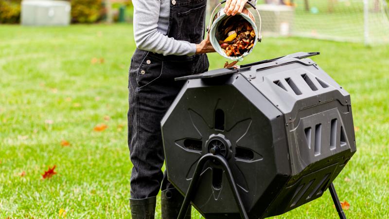 Women Filling Compost Tumbler with food scraps