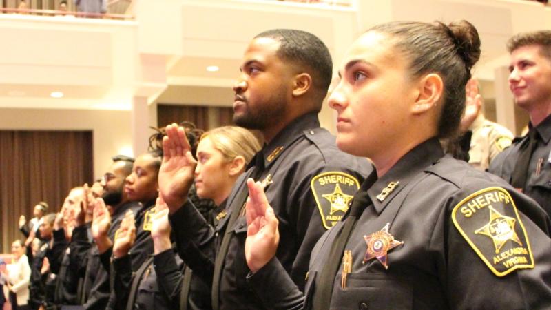 deputies in uniform holding their right hands up to take an oath