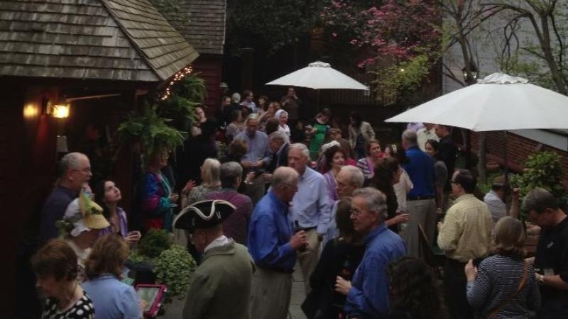 Image of group gathered in outdoor courtyard behind tavern. 