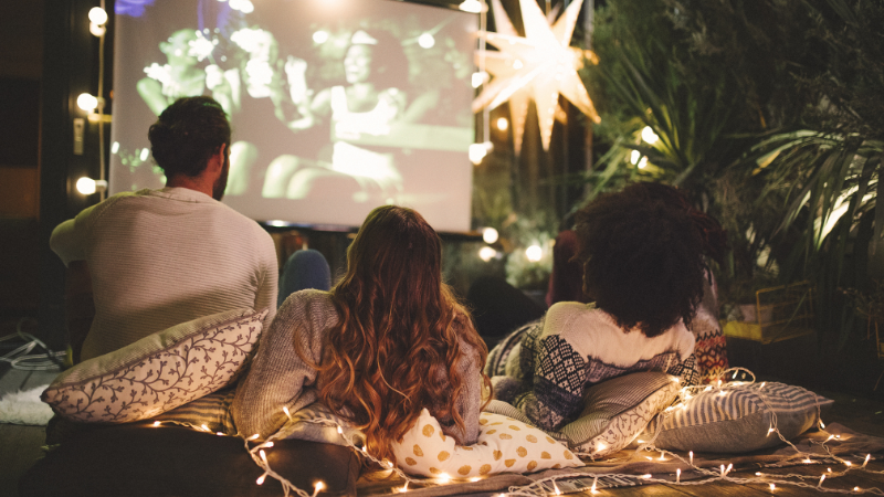 family on blanket watching movie outdoors