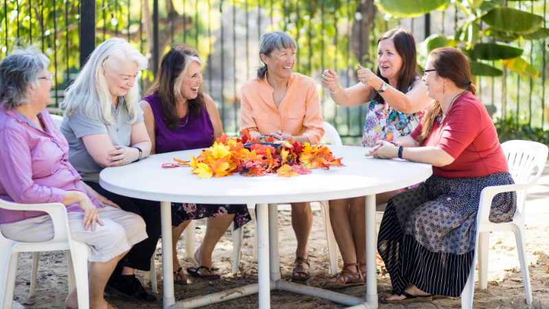 seniors sitting around a table with a fall leave centerpiece