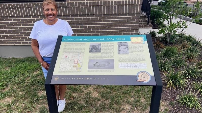 Woman standing next to sign