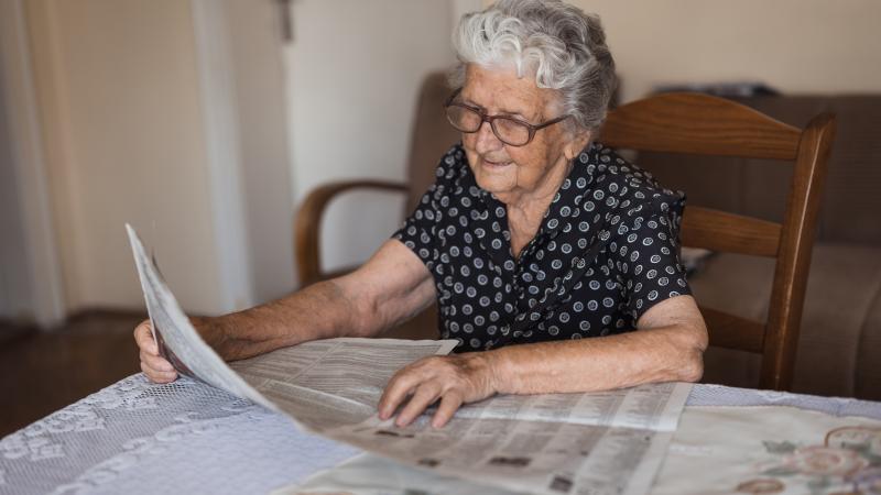 Picture of older woman reading a news paper