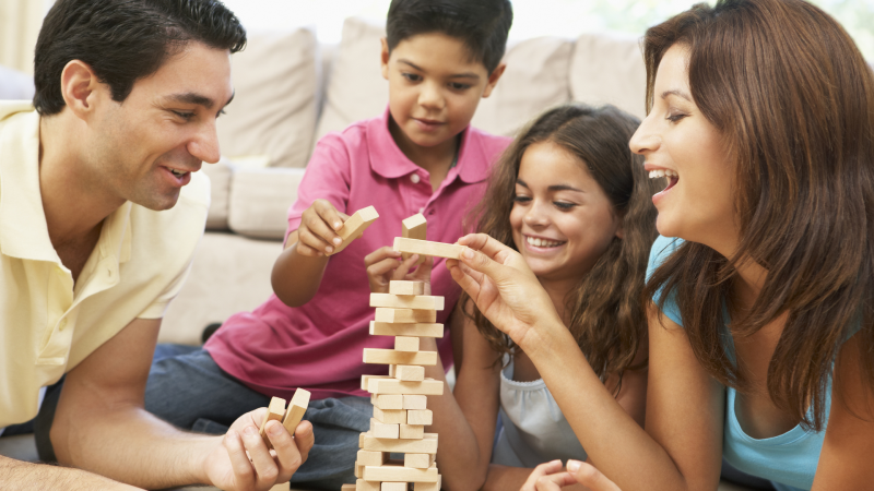 Family of four playing jenga