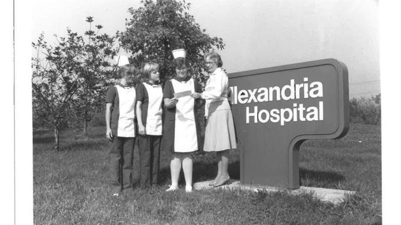 Check being presented in front of Alexandria Hospital sign