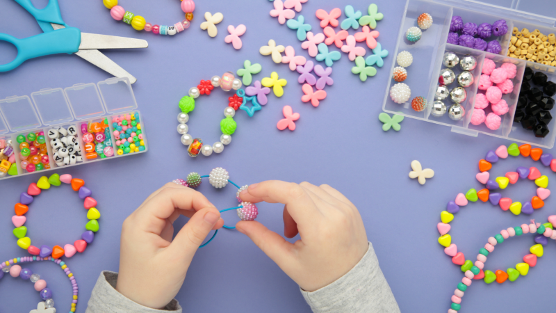 Hands making bracelets and other bracelet-making materials