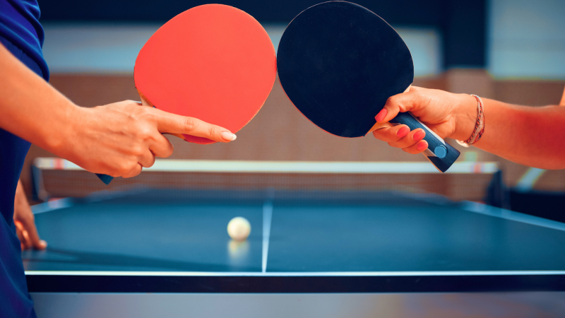 two hands holding table tennis paddles