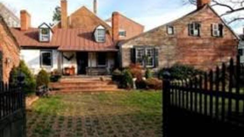 Image depicts view of side of Murray-Dick-Fawcett house and garden when entering from Prince Street. Ground is covered in a mix of bricks and grass.