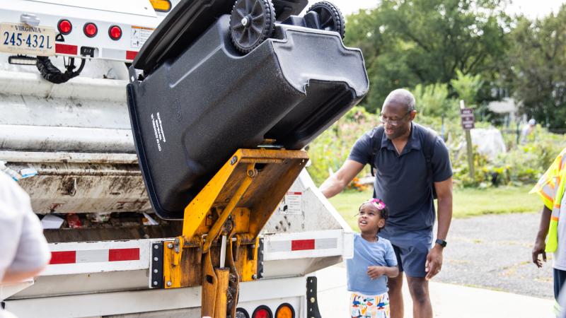 Attendees observe a trash truck