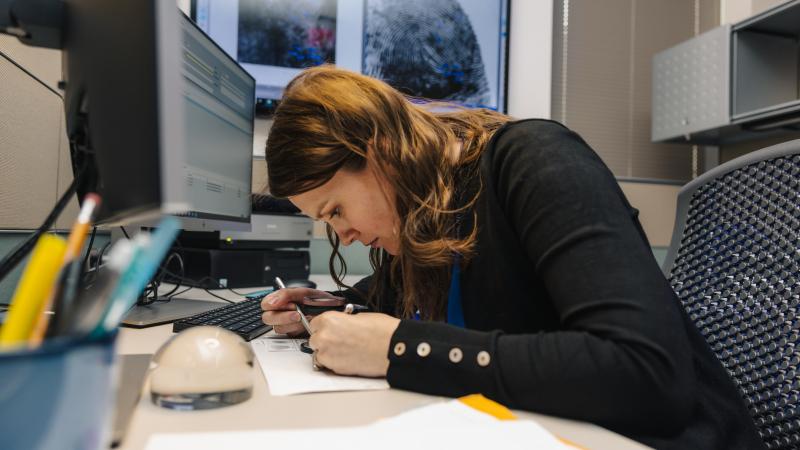 Officer inspects a fingerprint.