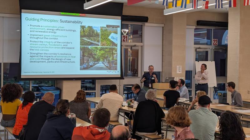Image of a community meeting with audience looking at a presentation