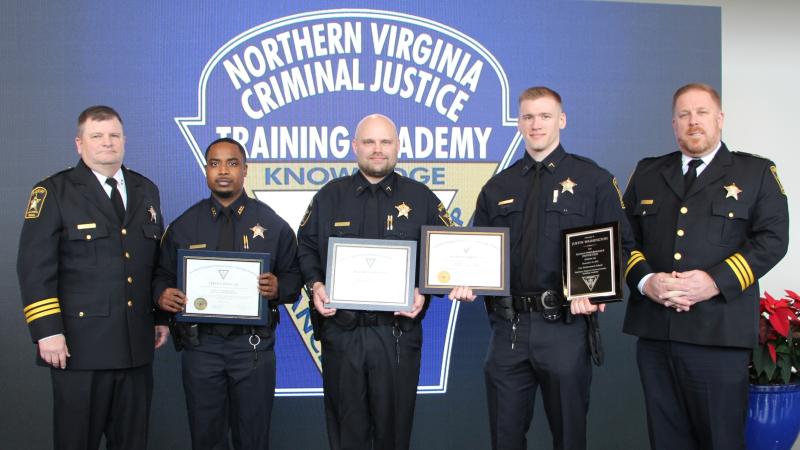 Five deputies wearing blue uniforms and the three in the center holding certificates