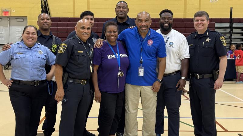 City staff posing and smiling inside the Charles Houston gym