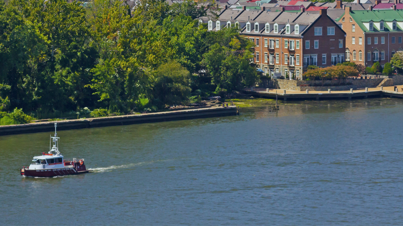 boat on potomac river with alexandria homes in background
