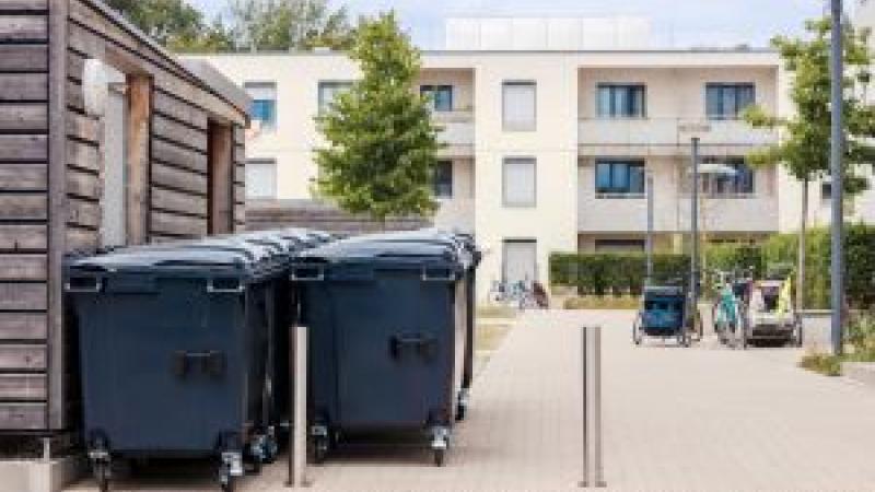 Blue recycling bins outside an apartment building