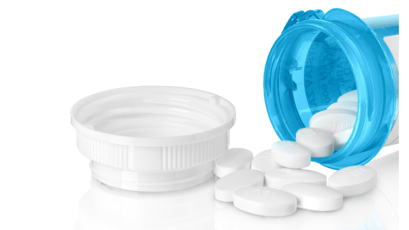 Blue medication bottle that is open with white pills
