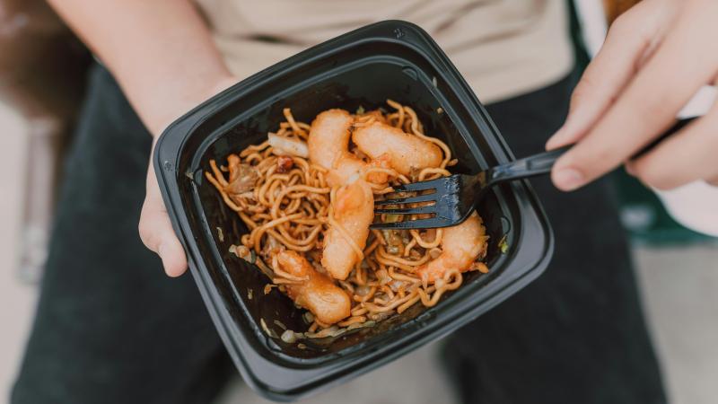 A Person Holding a takeout container