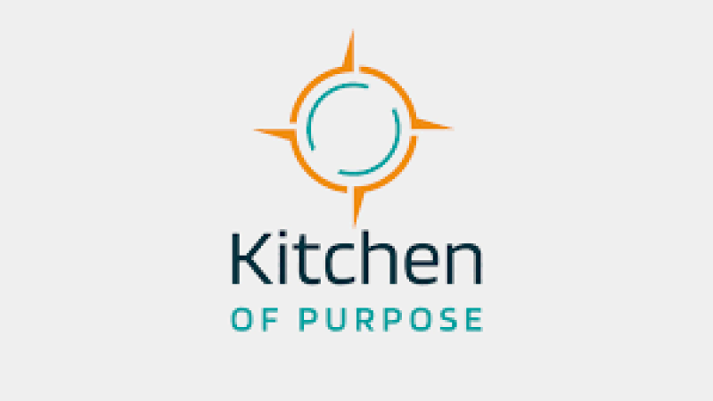 Logo of Kitchen of Purpose featuring a sun-like design and modern typography, symbolizing community and culinary creativity.
