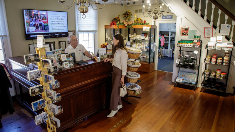 alexandria visitor center with front desk with man behind and woman speaking in front of the desk