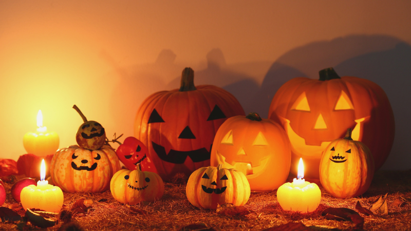 multiple pumpkins and candles on a tabletop
