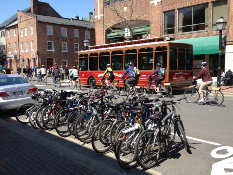 A photo of a bicycle corral filled with parked bikes on lower King Street in Alexandria