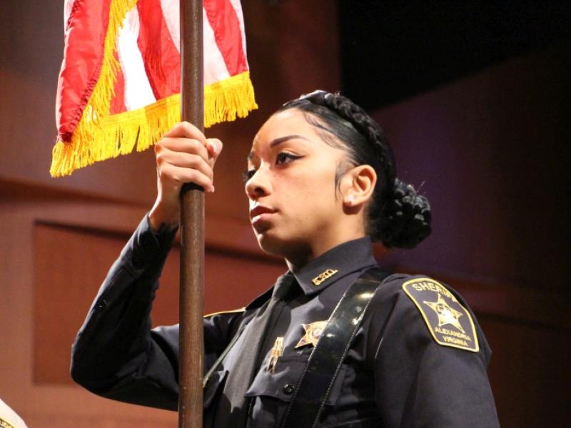 close up a deputy holding flag pole with part of US flag visible