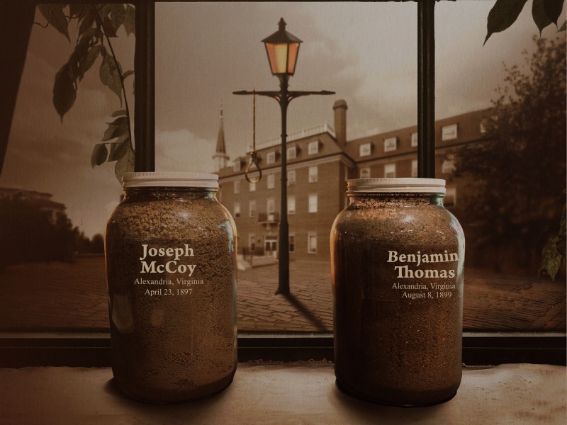 Two jars of soil with the names of Joseph McCoy and Benjamin Thomas on a windowsill in front of City Hall