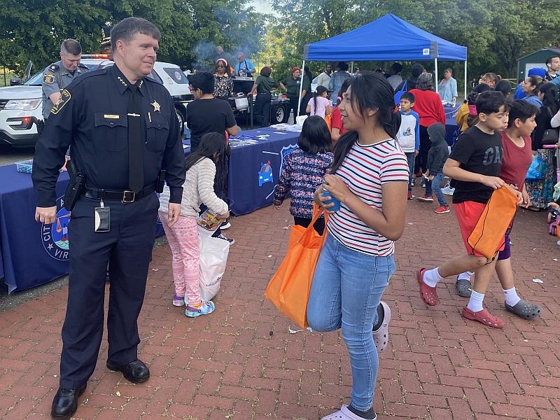 sheriff speaking with young woman at community event