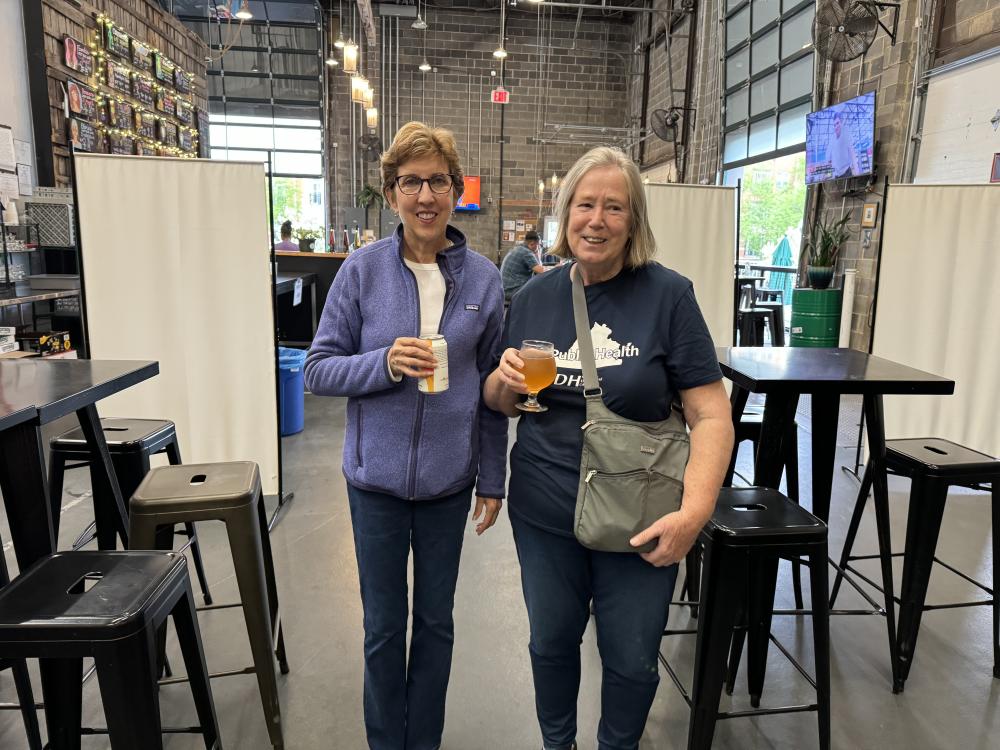 Two MRC volunteers smile with their beer